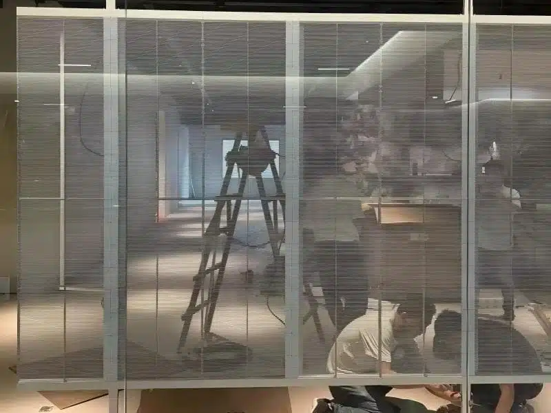 Engineer assembling P3.9 Indoor Transparent LED Curtain, showing the lightweight aluminum frame and modular fast-lock design.