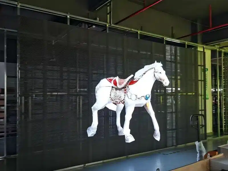Factory aging test of P3.9 Transparent LED Display showing high brightness visuals and 75% transparency with visible background.