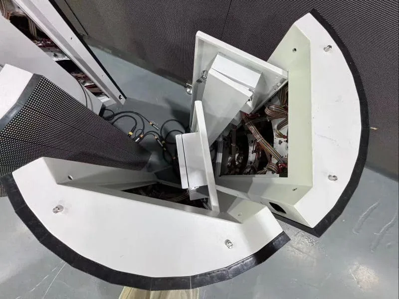 Top-down detail shot of a custom-designed curved LED display cabinet connection. High-precision CNC metalwork ensures a smooth arc and gapless splicing, essential for immersive naked-eye 3D visual effects.