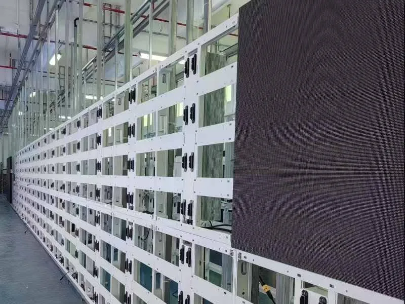 Factory production line showing rows of lightweight aluminum profile LED display frames. Front view with a single LED module installed to test fit. Designed for heat dissipation and weight reduction in outdoor fixed installations.