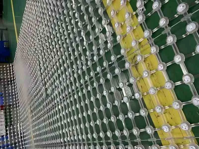 Close-up of a flexible outdoor LED mesh curtain layout in the factory. Shows the transparent grid structure and individual LED pixel dots. Lightweight and rollable design for large-scale building media facades.